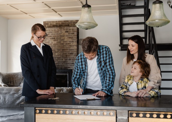Young family signing contract to purchase a house